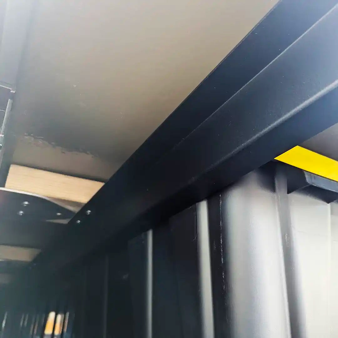 Close-up of a metal beam with a yellow storage bin top and 8020 extrusion frame of PLAT platform truckbed system expanding usable space
